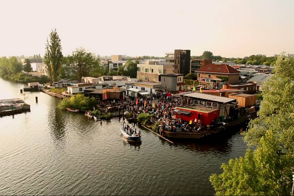 Boats gather on the water in Amsterdam as people gather at circular living lab "De Ceuvel" in Amsterdam North.